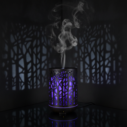 Dark Forest Branch Aroma Diffuser glowing blue-purple with hollow branch cut-outs casting shadows in moody dark room